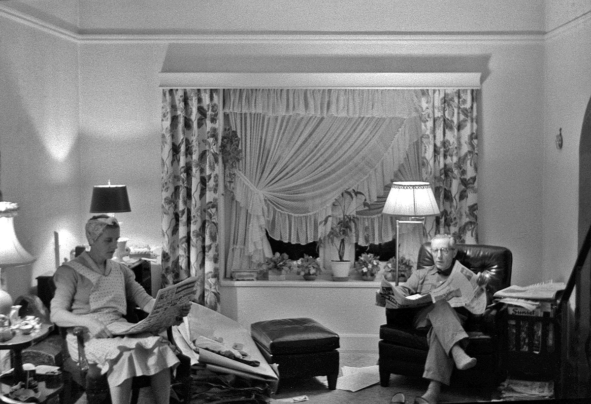 Previously in our living room we saw what it looked like with the family dressed up and posed formally. Here's what real, every-day life was like, captured by my brother in this candid, available light shot on 35mm Kodak Tri-X on April 21, 1955. Newspapers strewn around on the floor; my mother in her ubiquitous apron with her hair up in curlers; Father with his slippers kicked off, looking up from his paper (looks like our local Marin County daily, the San Rafael Independent-Journal) across the room at the TV. What that giant pile of stuff is next to my mother I haven't been able to figure out; some big, fabric-related project of hers perhaps. Where am I? My guess: behind my brother, on the floor, eyes glued to the TV. View full size.