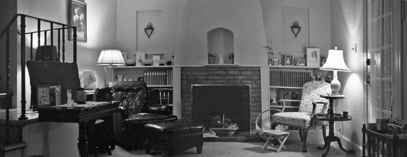 On the left: Father's chair; on the right: Mother's chair; not shown: Father and Mother. Why they're not there is unknown; possibly I chased them out to take this panorama, which film grain fans may detect consists of two 35mm Tri-X negatives. Otherwise, Father would be reading the papers, Mother doing a crossword and both, perhaps, watching the TV, which was all the way across the room behind me. Up the stairs to the left is my room, and I'm otherwise evidence in a younger version in the photo on the desk. Elsewhere are displayed other family members, including my brother, sister, maternal grandmother, youngest nephew and aunt-by-marriage. Notable book collections: Heritage Press editions of Dickens, Twain and Carroll on the left, a c.1915 set of the Books of Knowledge on the right. Also, various beloved gimcracks and tchotchkes. Items on the erroneously-dubbed (by Mother) "tilt-top table" at the left indicate it's around Christmas. Finally, in the rack at right, a Sunset, "The Magazine of Western Living," which, of course, is the kind we were doing at the time. View full size.
