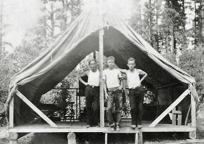 My first thought was 3 men camping, then when I saw this shelter tent placed on logs my thought was loggers. I have no clue as to who they are or what year it was taken.
