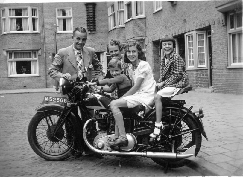 This photo was taken in 1937 in Amsterdam, Holland by Henk Kuipers, father of the 3 children on the motorcycle. From left to right the children are Henk, Tini and Loekie Kuipers. Behind them are Uncle Nico Grijpink and his wife Marieke. Nico is the owner of the British Ariel motorcycle, which they rode from their home in Nijmegen to visit the Kuipers. View full size.
