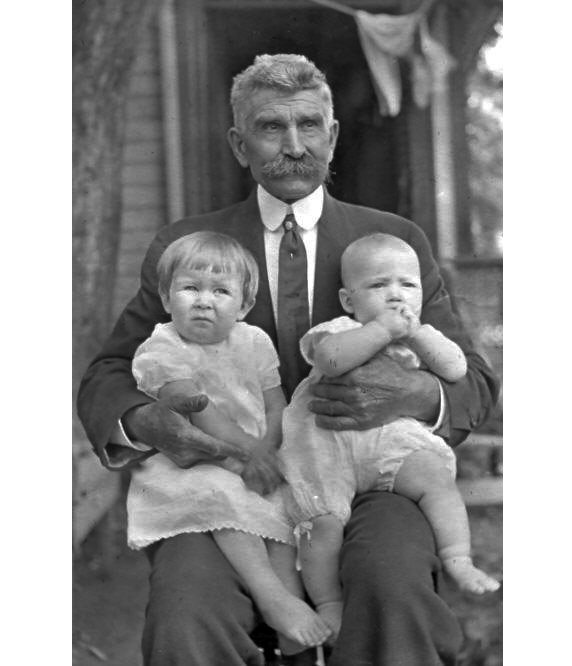 Howard Gunn Butcher was my paternal great-grandfather. On his knee is my father, Joseph H. Manning (right), and Helen DeWiggins (left), my father's first cousin. The photo was taken in Kansas.  Mr. Butcher was born in Indiana in 1855, and died in Iowa in 1915.