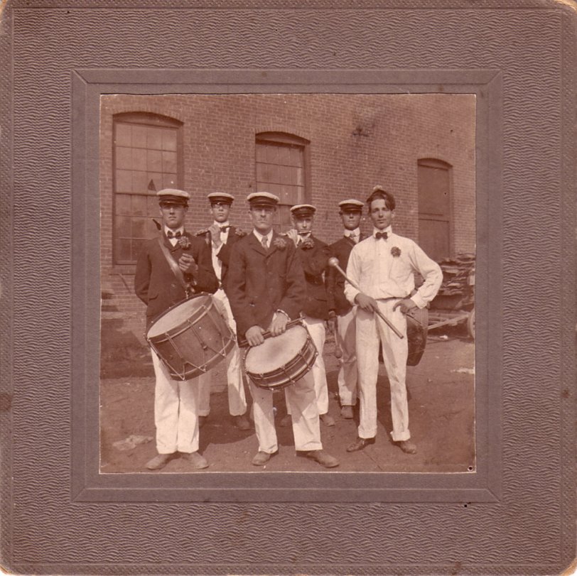 The Keene Matchless Fife &amp; Drum Corps, 1901, posing at the Diamond Match Company factory in Beaver Mills, a complex of mills in Keene, NH. Front: Ed Barrett, Archie Howard, drums; ____ Avery, drum major. Back, F.H. Tyler (my grandfather at age 18), Forest Hall, piccolos; Ben Symonds, bass drum. Beaver Mills was added to the National Register of Historic Places in 1999. It had also housed manufacturing operations including a saw hill, grist mill, furniture mills, and a pail manufacturer.
See an earlier picture of Beaver Mills here: https://www.shorpy.com/node/3235
