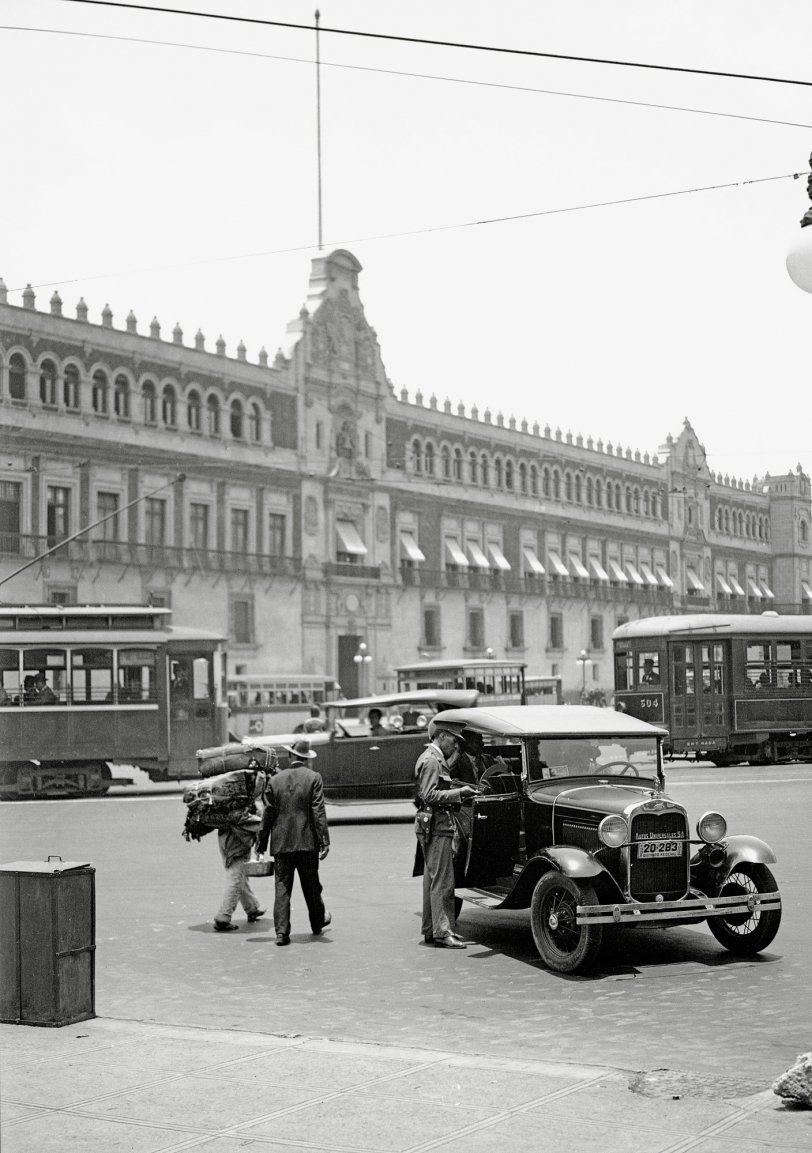 Driver in a 1930 Ford Phaeton talking to a cop in front of the Palacio Nacional, Zocalo, Mexico City, Mexico in 1931 or 1932. View full size.

