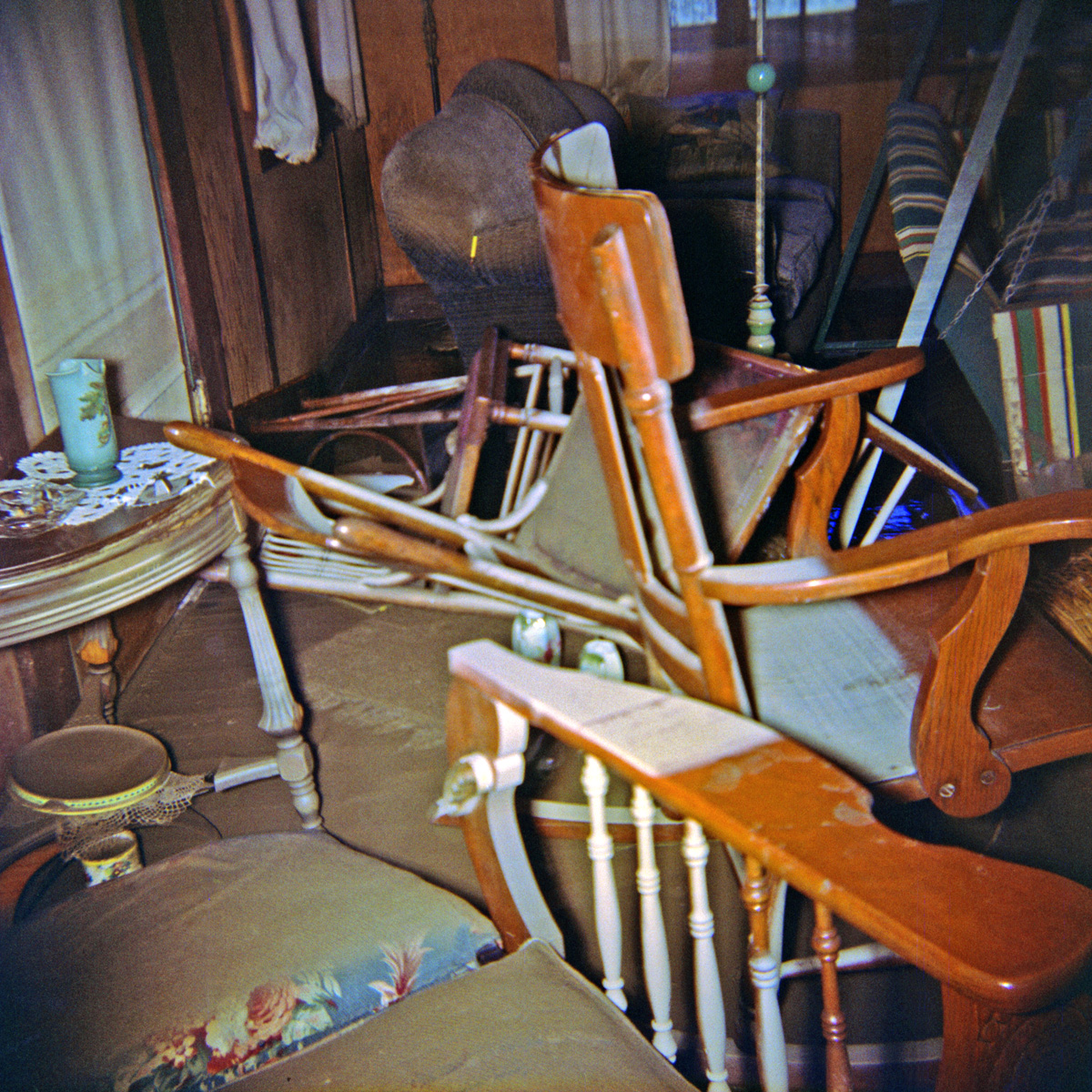 The living room of our summer house in East Guernewood, California, after the flood of December, 1955. Back then, this stuff was all considered junky enough for a summer cabin, but they'd be antiques today, particularly the Morris chair in the foreground. The porch swing had been brought inside for winter storage. This was definitely one of those world-of-reality crashes into world-of-childhood events for the 9 year-old me. I shot this on 2-1/4 square Kodacolor.

There's an exterior shot of the flood aftermath in the comments here.