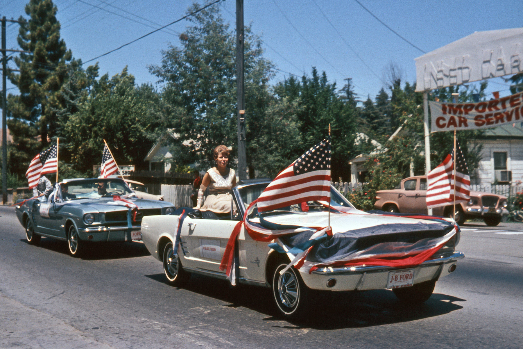 July 4, 1966. Twin Cities Fourth of July Parade on Magnolia Avenue in Larkspur, California. And if two brand-new, dealer stock Mustangs weren't enough, an early Studebaker Lark in the used car lot. The other Twin City was neighboring Corte Madera. My Ektachrome slide. View full size.