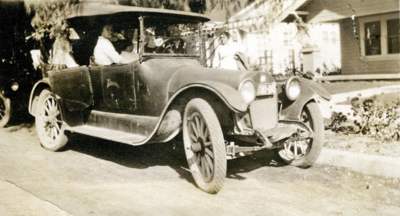 A neat old 1920's car full of people. What kind of car it is and what it says on its door stumped the crew I was with on June 4, 2014. We drove a 1956 Studebaker to an antique store in Simi Valley, California. I bought 71 old photos (mostly of cars). Then we sat down to figure out what the cars were. No guesses on this one. View full size.
