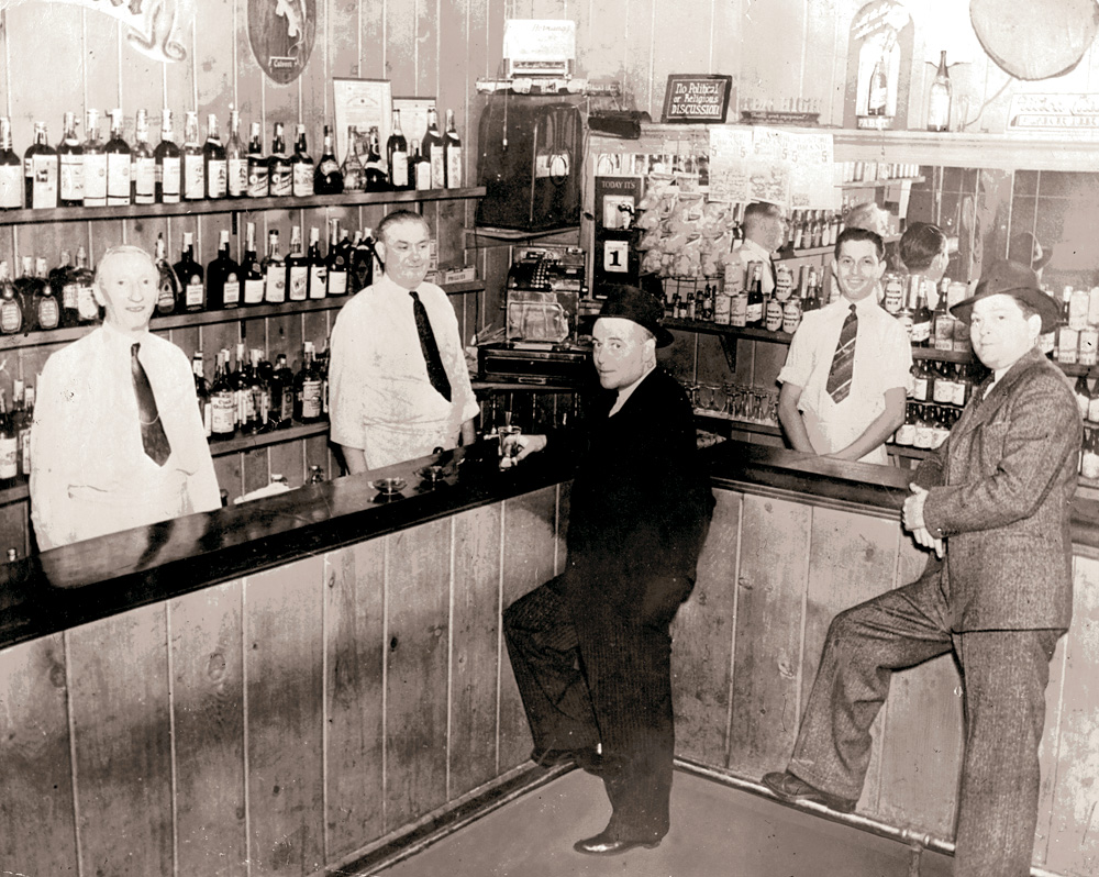My grandfather William Kelly, here at the far left, immigrated from Ireland in 1907. He worked as a waiter, then eventually bought the restaurant in Philadelphia. After operating it for many years he retired and then tended bar in this local establishment at 59th and Nassau. The owner, Mr. Morris, is to his left. The photo is from around the 1940s. View full size.