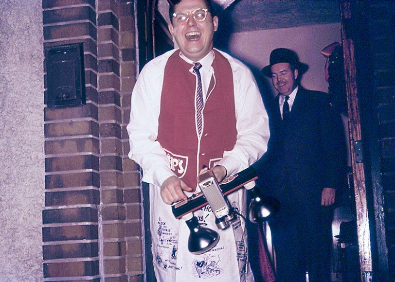 As I grew up on Esdras Place in Riverside (now Windsor), Ontario, in the mid-1950s there were some big parties. Harry Slobasky is pictured here ready to document the shenanigans. The man wearing the fedora behind him bears a striking resemblance to Howard Hughes. Their home had a large basement rec room with wet bar, and on Saturday we would visit and be treated to Coca-Colas. Racy artwork adorned the walls. This may have been the final stop for a progressive dinner and a party to ring in the New Year. My father took this Kodachrome slide. A happy New Year and a big thank you to all the folks at Shorpy. View full size.
