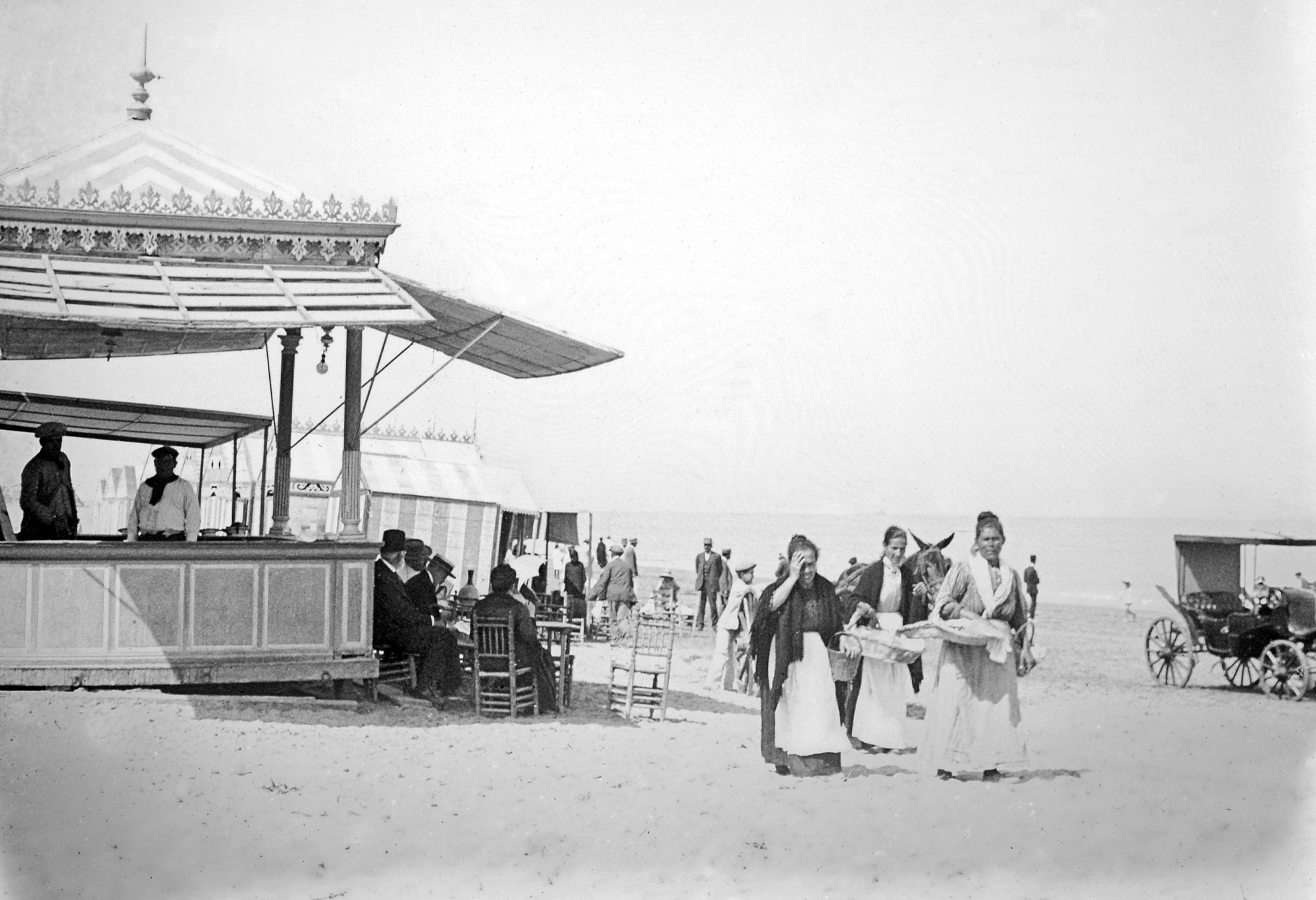 A typical day on the beach under the hot Spanish sun, Sanlucar de Barrameda, Spain, c.1910. Positive in glass taken by my great-grandmother's brother. Any bathing-suits? Anybody sun-bathing? What a difference with any beach on the "civilized" world today. View full size.