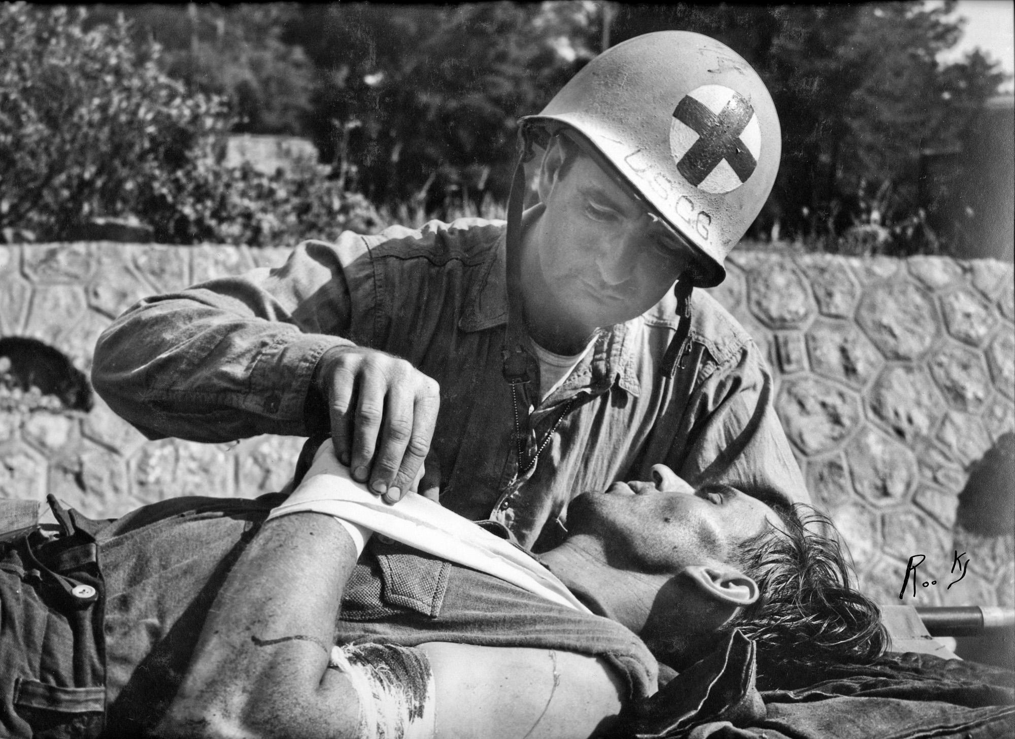 In this image, my grandfather John "Jack" Baker can be seen treating a captured German soldier. It is believed that this image was taken in Southern France – possibly near Baie de Cavalaire. Although the exact date isn’t known, it is likely that the event took place from August 15, 1944 to September 10, 1944. This image was taken by Dale Rooks, and may have been featured in a news magazine at the time. The date estimate is based on the official history of the USCG USS Duane, which Baker and Rooks were both assigned to. View full size.