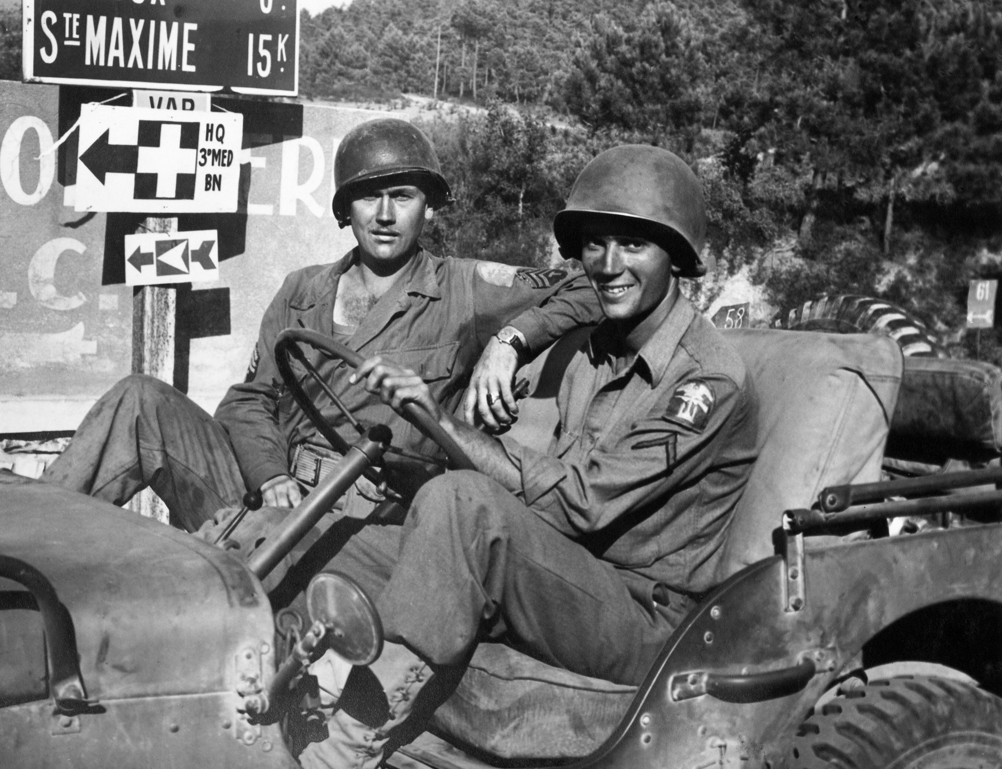 This photograph comes from my grandfather John "Jack" Baker's Warbook. It is of two unknown Army GIs in Southern France. Based on the large road sign, we can assume that the location of this photo is 15 kilometers from Sainte Maxime. In the right hand side of the photo, you can also see a sign with the numbers 61 on it. This is likely D61 which would mean the picture was likely taken around Port Grimaud. Although not signed, this photo was probably taken by Dale Rooks sometime in the last two weeks of August, 1944. View full size.