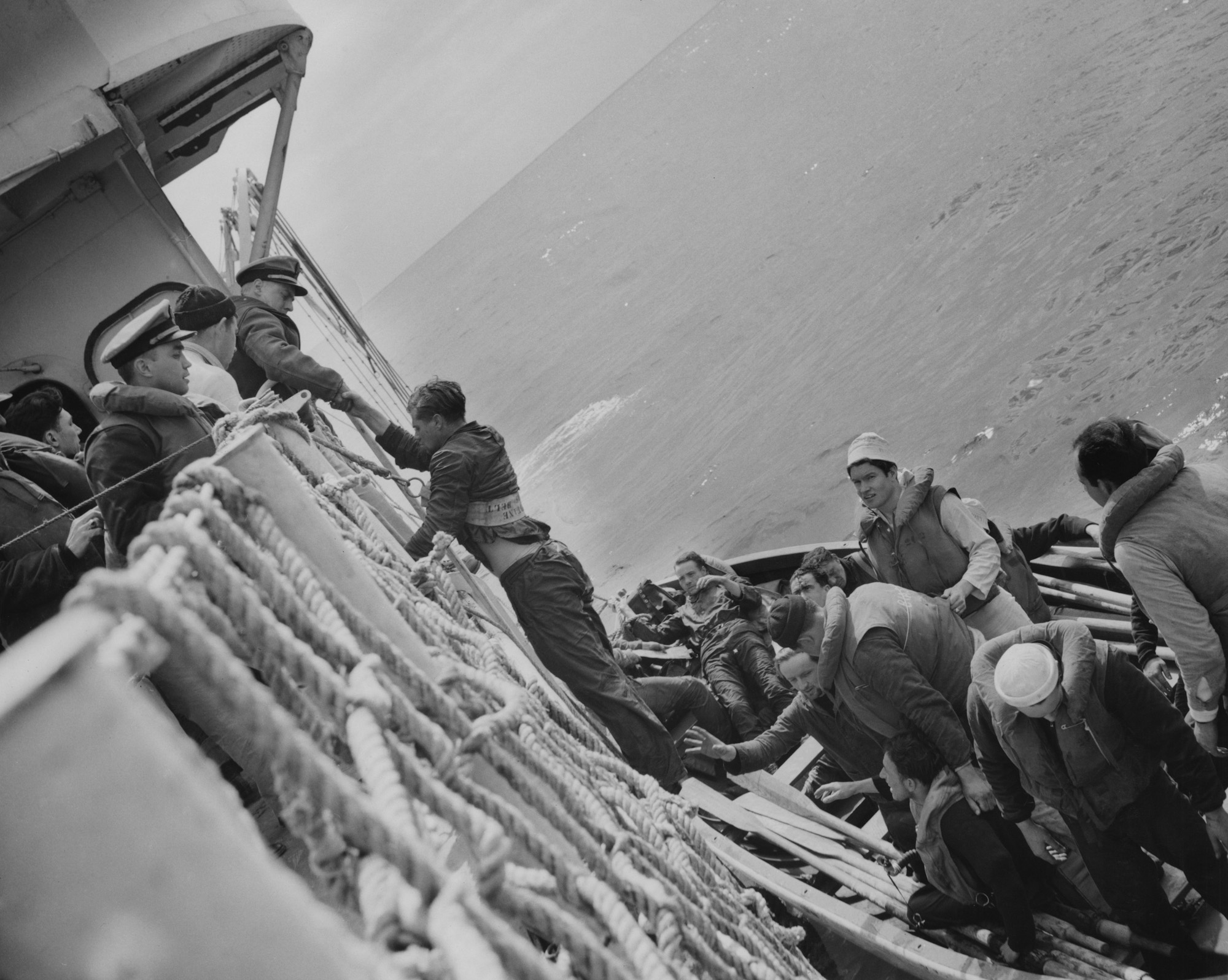 This photograph was scanned from my grandfather John "Jack" Baker's Warbook. This photo is of Nazi soldiers being helped aboard a Coast Guard cutter after their U-Boat (U-175) was destroyed in a battle. This photograph was taken aboard the USS Spencer by Jack January on April 17, 1943. The event took place in the North Atlantic while on a convoy mission (HX-233) from the United States to the United Kingdom.

Although my grandfather had told me about this event numerous times, the part that he recounted the most was what happened shortly after the Nazi's were brought aboard -- they were given ice cream. He said that in all his years aboard the USS Duane, he was never given ice cream. Even further - he was a medic and he was obligated to treat them. Despite the fact that the USCG cutter ships were firing weapons at these men moments earlier, he now had to give them medical attention as they ate ice cream in front of him. View full size.

The official recount of the story can be found here. 