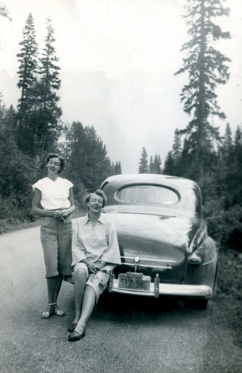 Two women (one of which appears to have a cigarette) wearing what were called pedal pushers or capri pants, stop on the side of a road to have their photo taken. I don't know why. But I like them and their car. From an assortment of car pictures I found in an antique mall in Simi Valley, California. View full size.
