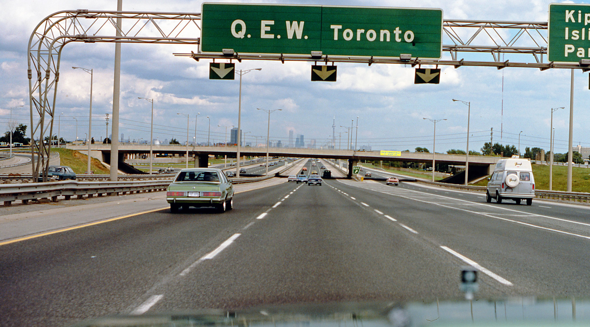 This is the first of three submissions, taken from the driver's seat on a trip eastbound on the QEW to Toronto (Queen Elizabeth Way, opened as the first concrete controlled-access divided highway in Canada, between Toronto and Niagara Falls, by the King and Queen of England in 1939). This was Sunday morning, Labour Day weekend, 1979. That's why the highway is surprisingly open, but there're still enough period vehicles to see.

These shots were a lot harder to do than today, as I had to look through the viewfinder of my SLR film camera. When you're young, stupidity in the mirror is closer than it appears. View full size.