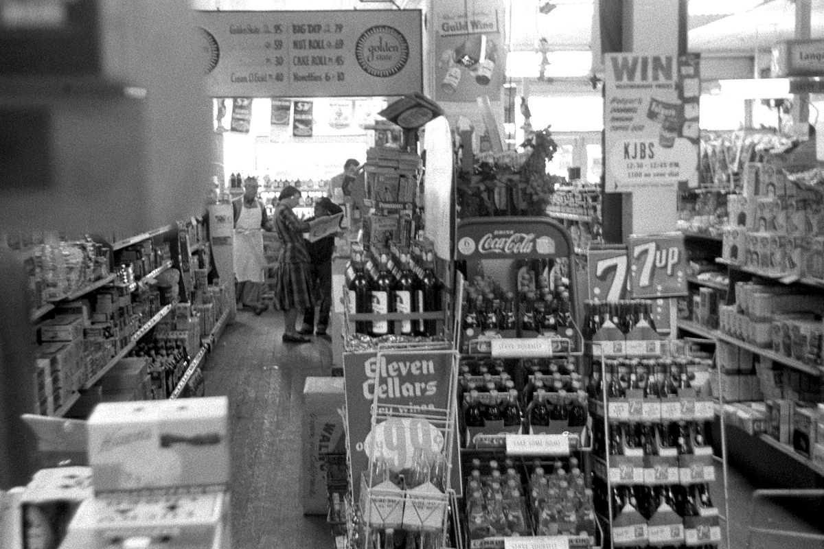 April 21, 1955. Inside the Rainbow Market in Larkspur, Calif. After my father sold his store in San Francisco, he worked here in one of our home town's two grocery stores for a few years. That's him in a white apron at the end of the aisle. The exterior of the building can be seen here. My brother also took this shot while he was at it, also on 35mm Tri-X. View full size.