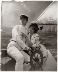 Two women, one in men's clothing, on a sailboat in a studio shot. Photo by Fritz W. Guerin, c. 1902. View full size.