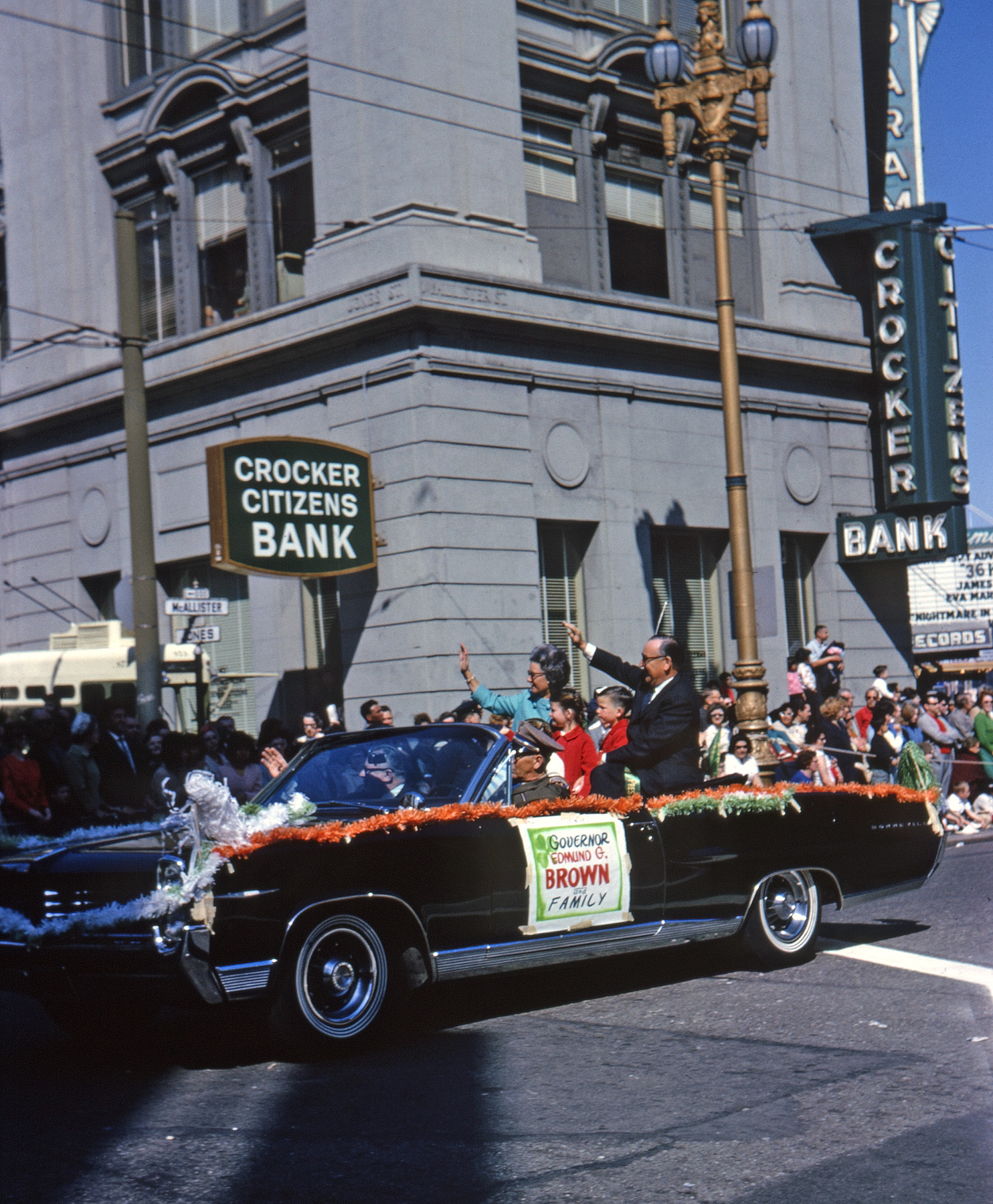 San Francisco, March 17, 1965. California Governor Edmund G. "Pat" Brown, Sr., father of  Jerry, in the St. Patrick's Day parade at Jones & McAllister, off Market St. Those are probably his grandkids. I shot this on 35mm Kodachrome. View full size.