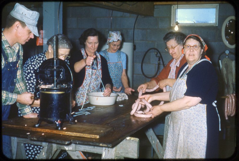 Champaign, Illinois. My family making sausage on the farm, in the winter of 1954. The lady in the back, on the right, has obviously just had a great idea. View full size.
