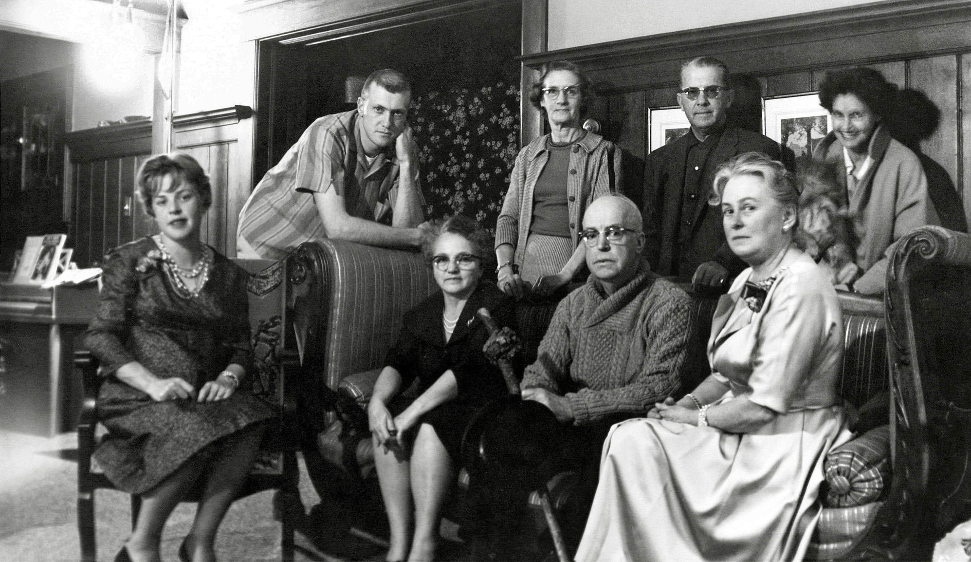 Here's my contribution to that popular Shorpy genre, the unsmiling-group photo. In this case, it's because I told them all to stay verrrry still for the brief time exposure. I was using the only camera I had access to at the time that could do that, an old c.1935 Kodak Junior Six-16. The negative is long gone, so I scanned this from a period print.

My mother is standing in the back at center, and we're in the Larkspur, California home of our friends, the man on the couch with the shillelagh and his wife seated at right. At the left is their daughter and her husband. She was recently seen in this same wainscoted room here. The only one who moved during the exposure, probably because she's trying to restrain her squirming pomeranian, is our neighbor at upper right, the mother of one of my childhood chums. I may have known who the other couple was at one time, but no more. View full size.