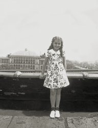 My then-seven-year-old future mother poses on the roof of her apartment building (1027 44th St, Brooklyn NY) for one of her parents to take her picture. She lived in that same apartment from birth until she married my father in 1951.
What is most interesting about the childhood  pictures of my mother from this era is that she is always in the same dress. I am quite sure, unlike Little Orphan Annie, she had more than one dress to wear. But somehow the same one was chosen for every photo.
(ShorpyBlog, Member Gallery)