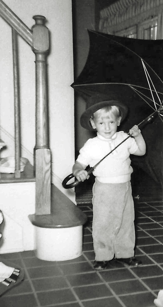 I was not the only child who liked to play with an umbrella. Seven years later, my then-three-year-old brother found my father's hat and black "bumbershoot" in the hall closet and began to play. Photo was taken by my mother. Scan was made from a print.
