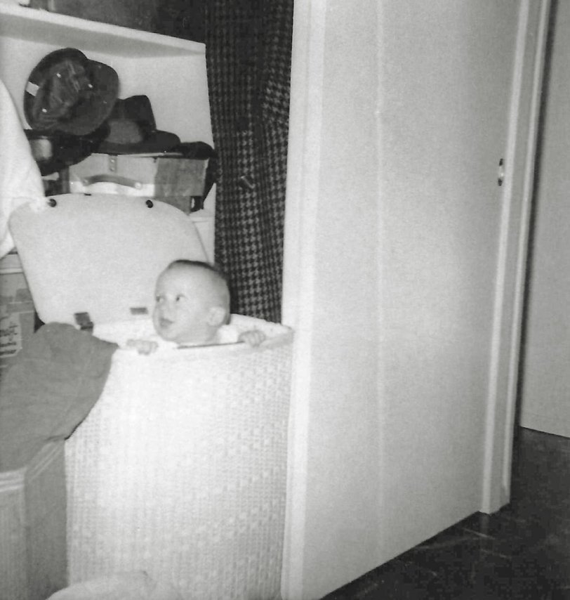 My brother was the best toy my parents ever gave me. He was born the summer after I completed first grade. You could hold him and feed him. You could dress him in doll clothes. Whatever you did, he loved it and came back for more. Here I apparently put him in the laundry hamper that was in the hall closet of our Levittown Pennsylvania home. He seems to have liked that too.
