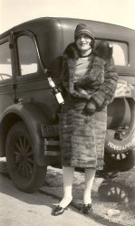 My Great Grandma Rae Keavy, who was married to Jack Keavy, a member of the Minneapolis mob. The date on the photo is unknown, but probably sometime in after 1925. View full size.
Date?Fiddling with the image in Photoshop, it appears that the license plate shows an upper-case E or perhaps B over 28, then, in larger type, 96-M. The balance of the plate is hidden by her coat.
If the 28 is correct, and indicates the year, then it ties in nicely with your dating of the photo as sometime after 1925.
I tried to read the label on that bottle, but no joy.
--Jim
unknown dateWe have a lot of other pictures of her on cars around this time frame, only one has the year 27 visible on the plate, but its a different car so the 28 is possible. 
Nice PhotoRae was my Great Aunt..... I spend a lot of time with her when I was young. I was with her when she passed away in 1960.
(ShorpyBlog, Member Gallery)