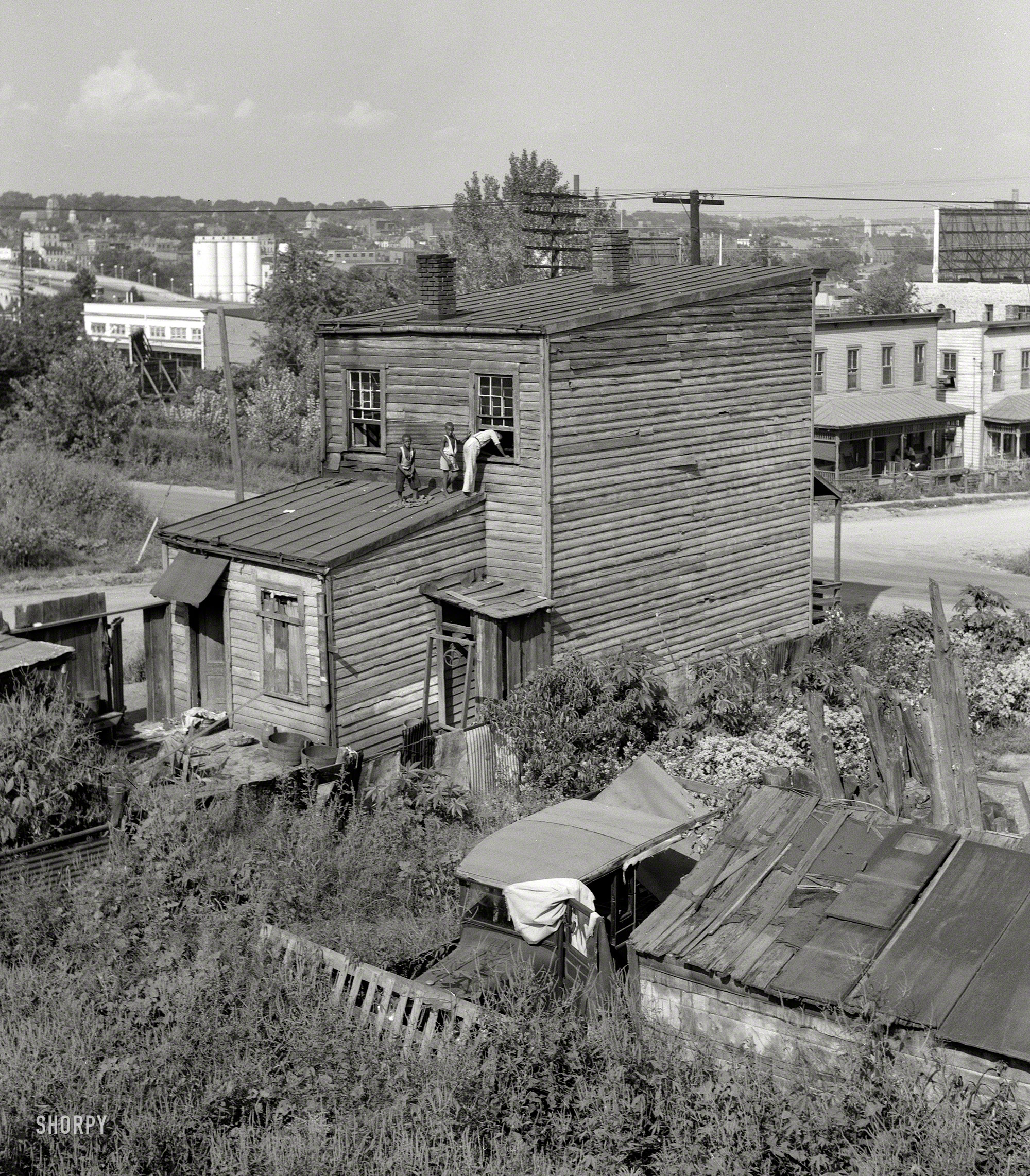 September 1937. "House in Negro quarter of Rosslyn, Virginia." Washington, D.C., and the Key Bridge form the background for this curious scene. Medium-format negative by John Vachon. View full size.