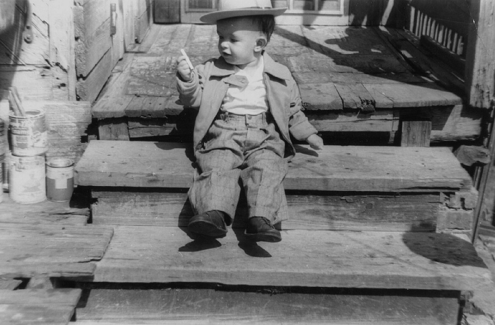 The caption on the back reads "Cigarette only 16 months."  His parents probably let him play with the cans of lead paint off to the left, too. View full size.