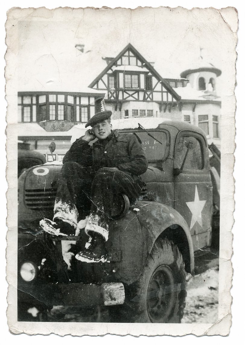 Walter on his Dodge tipper, outside the Belgian Chateau they were billeted at somewhere near Boom, between Brussels and Antwerp. Winter 1944.
Quiet Mike: "You said you were in Antwerp for Christmas?"
Walter: "I went to stay with my friends at Estelle’s. I went up there, we’d got a wagon, a liberty wagon, and we went up to somewhere not far from Fort Seven, I can’t think of the name of it. It was by Fort Seven. Then I’d got a tram into the city and went to see my friends, and it was bad weather, it was snowing. I left Estelle's, early enough, and got the tram back, but there was some sort of hold up, and when I’d got back the liberty wagon had gone. So, I didn’t really know what to do, and it was snowing as well. I got back onto the road, and was walking back. I didn’t know what I was going to do mind you.
"Anyway I started walking back, and looking around all of I sudden I saw headlights. I waved him down, and it was my mate. It was our dispatch rider, George Rand. I couldn’t believe it! He’d pinched a truck and gone up into Antwerp. It was my good fortune really. I stopped him and got in. He drove us to the gate and parked it by the side of the road. I said 'Are you on duty?', 'No, I borrowed it.' Good for me, and I got back in time." View full size.
