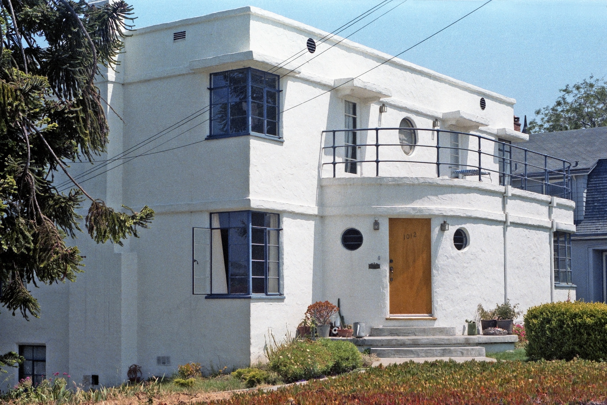 A classic example of 1930s Streamline Moderne architecture in a Santa Cruz, California house I photographed in 1984, showing a number of characteristic elements: porthole and corner windows, the rounded edge of the entryway, the flat roof and white stucco surfaces. Unfortunately, the current Google street view shows it's acquired a color scheme not in keeping with the spirit of the style. A 35mm Kodacolor negative. View full size.