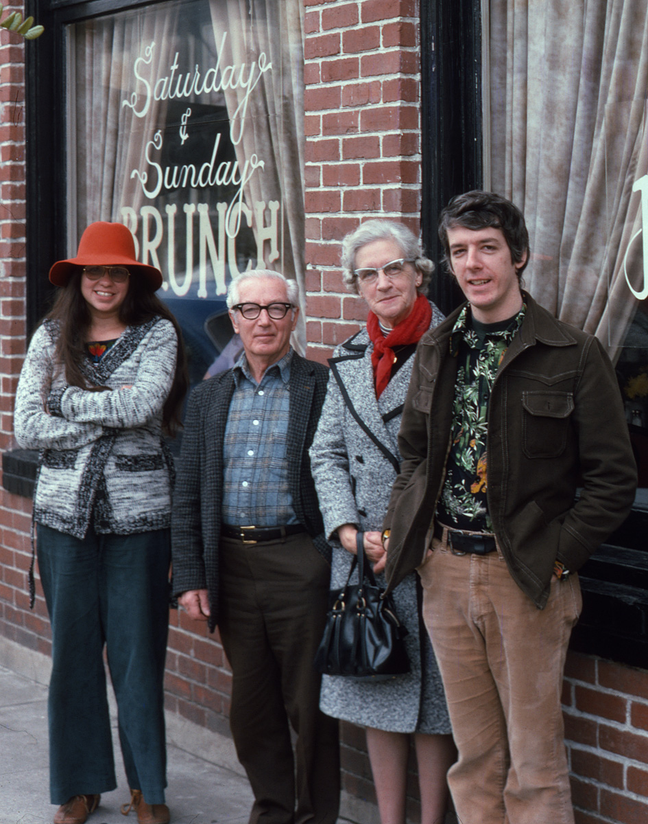 Family, food and fashions of the 1970s, as demonstrated by my sister-in-law, my father, mother and me on a Sunday morning in January, 1975, captured by my brother on Kodachrome. Once again, sis-in-law wins the arresting garb sweepstakes. Love that hat. I was quite fond my shirt, too. This week in San Francisco, I spotted two young women with glasses exactly like my father's.

We're gathered in front of the late, lamented 464 Magnolia Restaurant in, you guessed it, Larkspur, California. Through the 1950s, the building was the local telephone exchange. Adjoining buildings housed the hardware store, pharmacy and dry goods emporium. Today they've all been consolidated into an upscale café, coffee house, deli and patisserie complex. The rest of the old everyday establishments have long given way to other fancy eateries, boutiques, art galleries and management offices.  The main link to my childhood in downtown Larkspur is the barber shop, which still has the very barber chairs I squirmed in while getting shorn. Fortunately, the local historical preservation ordinance has prevented all exterior changes except for paint color, so the town still looks relatively unchanged. View full size.