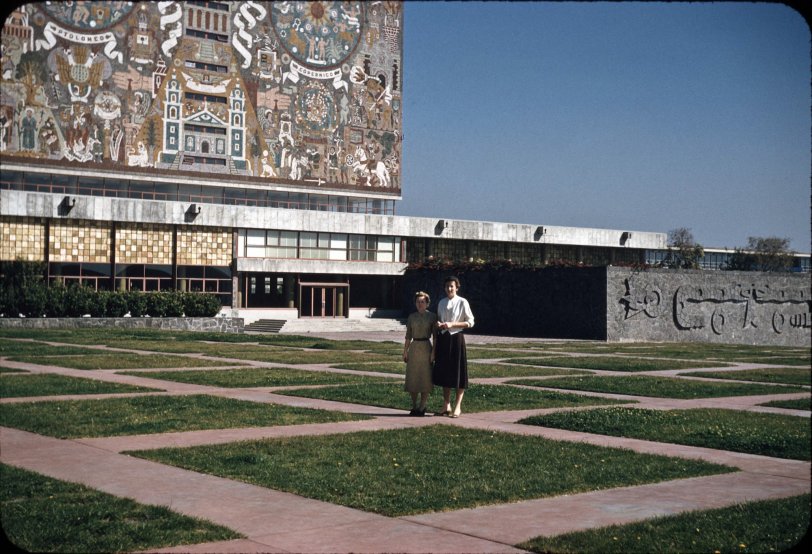 Ciudad Universitaria (University City), Mexico is the main campus of the National Autonomous University of Mexico.  Located in the southern part of Mexico city its construction on a solidified lava bed was finished in 1954.
My Aunt Lee is on the right (I'm assuming that Aunt Emmy took this picture since that is not her by Lee's side). My Aunts, at ages 38 and 40, were on their first international trip. At the time of this trip they had worked at least 15 years as executive secretaries at GM divisions in Anderson, Indiana.
The mural pictured here is recognized as the largest mural in the world, covering all sides of the Library. The mural is based on Aztec and Spanish motifs and UNAM's coat of arms.  The artist was Juan O'Gorman, a painter and architect. 
The image was digitized from a 35mm Kodachrome slide. View full size.
