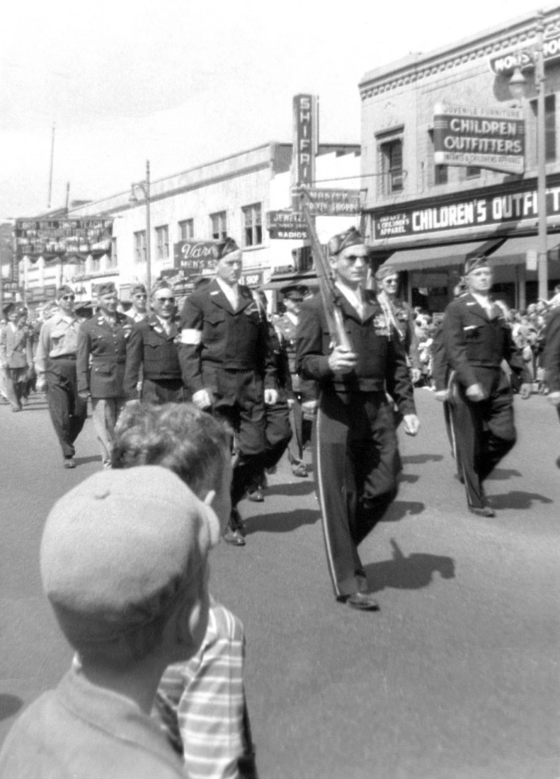 WWII Veteran’s Day Parade, early 1950s.
Location: 13600 Michigan Avenue, Dearborn, MI.
Unfortunately, the City of Dearborn covered up many of its downtown buildings with modern facades in the 1980s, thereby obliterating their architectural beauty.
Photo 2 of 2 of my black and white parade series
Image courtesy of the Box of Curly Photos from my parents. View full size.
