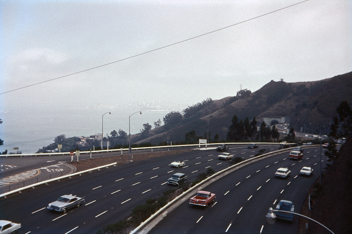 October 1964. U.S. 101 above Sausalito, Calif., the Waldo Grade approach to the Golden Gate Bridge. Similarities after 44 years: same number of traffic lanes. Differences after 44 years: many more cars, but none of them have fins. My color slide with Montgomery Ward brand film. View full size.