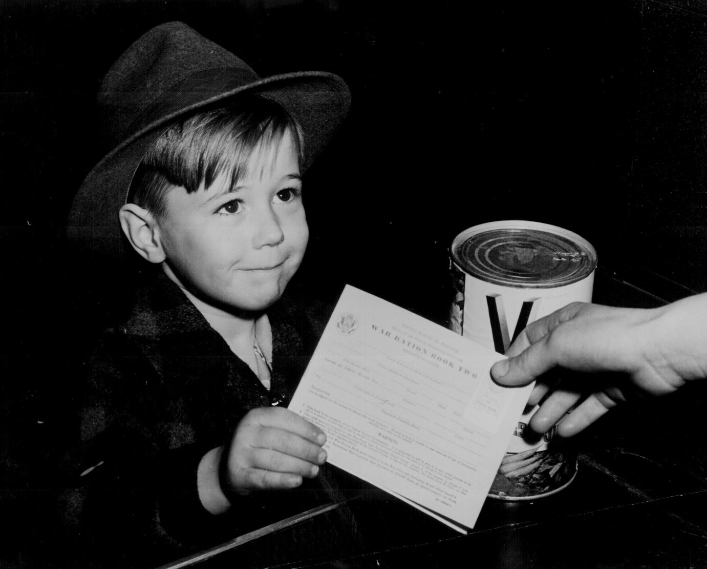 With many parents engaged in war work, children are being taught the facts of point rationing for helping out in family marketing. February 1943. View full size.