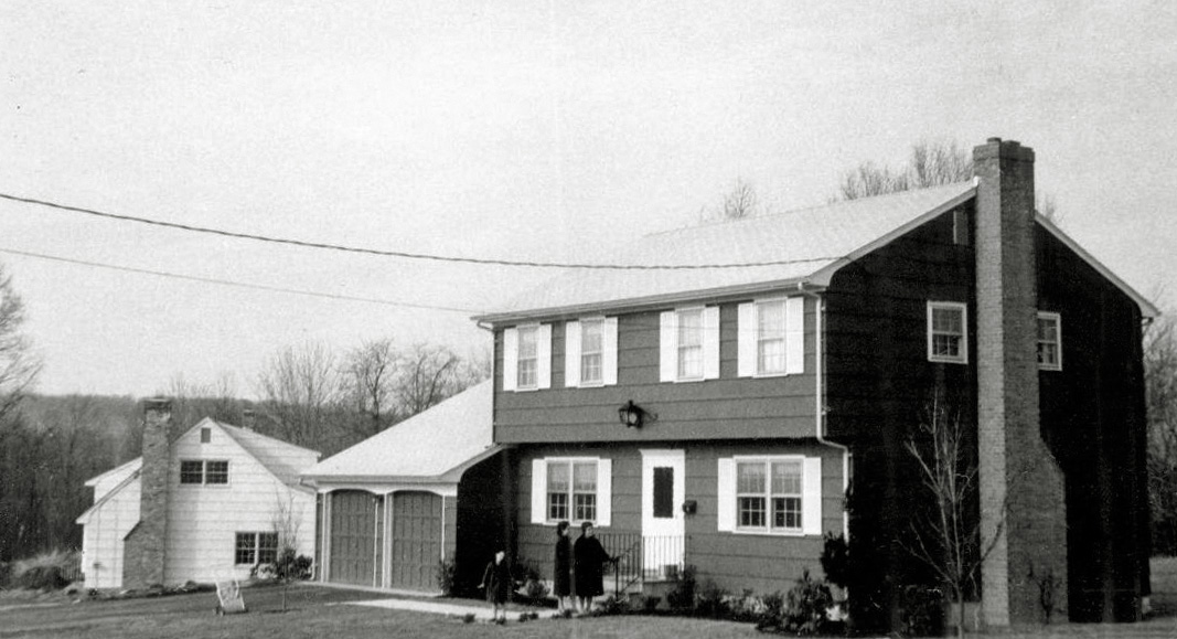 We moved into the new house at 85 Leabrook Lane, Princeton, NJ, on July 30, 1962. After we moved in a lawn was planted and the street paved. I watched with fascination as they completed both those tasks. You can also see the completed chimney and the electric line to the house. Being one of the first houses in a neighborhood gave me lots of chances to see and hear how homes were built, and lots of dirt piles to play in and house frames to use as my personal monkey bars. I am quite sure if any adults really knew what I did and where I climbed after the workmen went home they would have been horrified. But I never got any injury more serious than a splinter in all my shimmying up and down the wooden beams of the houses that came after ours. I am the eight-year-old girl in the winter coat. My mother is the adult closest to me and her sister next to her. My one-year-old brother's stroller is on the driveway. On the front step is a milk box; the man who delivered milk and eggs to it also left me a stick of Juicy Fruit gum every day. My father took the picture. View full size.