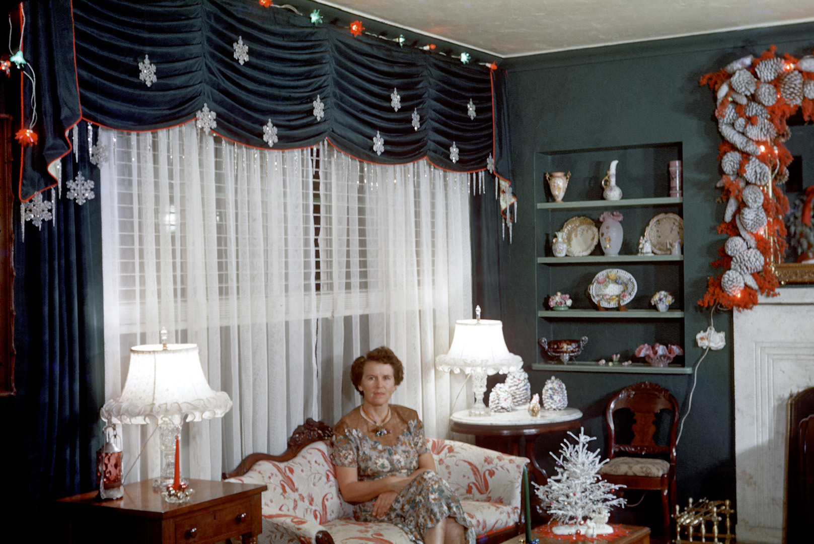 &nbsp; &nbsp; &nbsp; A holiday chestnut worth reheating over the Shorpy Duraflame.
"Christmas 1954." My grandmother Sarah Hall (1904-2000) in her living room in Miami Shores four years before I was born. She made the mantel decoration, which saw service for many years, with Brazilian pepper berries from a big tree in the backyard, mixed with pine cones, all attached to a chicken wire frame. Grandmother, handy with a needle and thread, also made the curtains. She was, needless to say, big on Christmas. 35mm Kodachrome. View full size.
