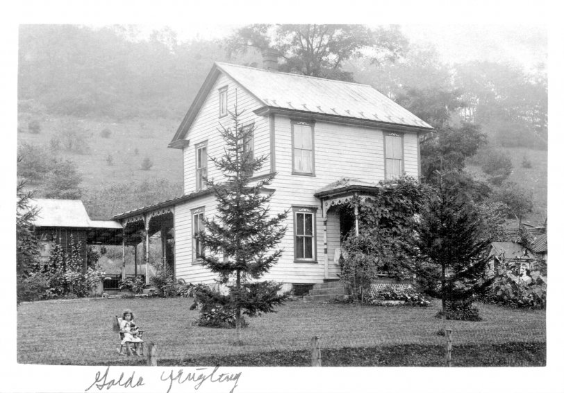 The little girl by the fence was my mother's cousin, Golda Yingling, whose family owned a grist mill near this beautiful small house (check the scrollwork above each window as well as the two porch roofs' embellishments), in Sproul, Pa., north of Bedford.
The photo was taken before 1920 but long enough after the 1903 debut of the Teddy Bear, one of which is enjoying the view with Golda (Aunt Goldie to me) of what became U.S. Route 220. Her name there is in my Mom's handwriting. View full size.
